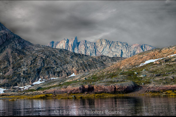 Rocky landscape with gray cliffs against stormy sky in Greenland