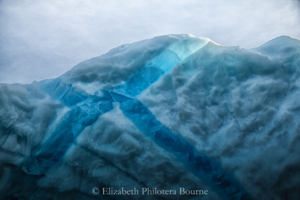 Top of iceberg with crystal blue veins lit by the sun in Greenland