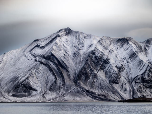 Photograph of black and white mountain with strangely curved designs