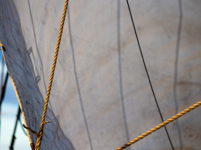 Photograph of a ship&#039;s sails and ropes.