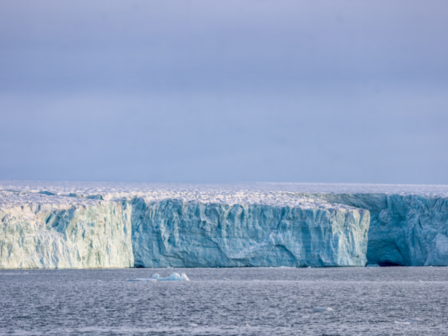 Photograph of long blue and white marbled glacier under a gray sky