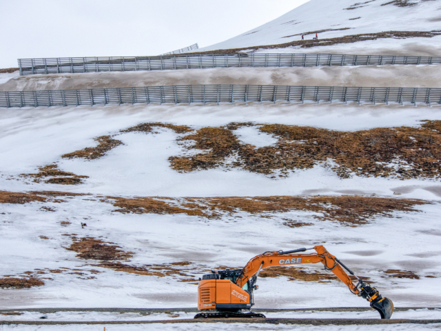 Site of the 2015 Avalanche Below the avalanche fence an orange steamshovel works in the area where houses were destroyed by an avalanche in 2015