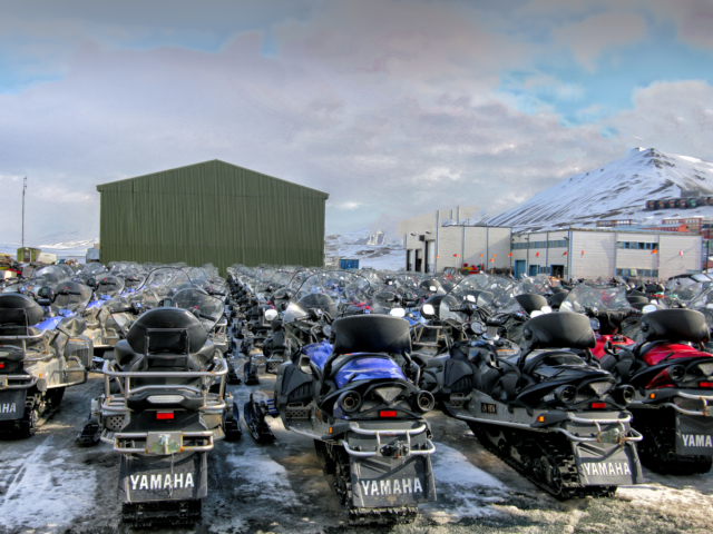Snowmobile Farm Snowmobiles waiting for tourists behind SSU in Longyearbyen Svalbard