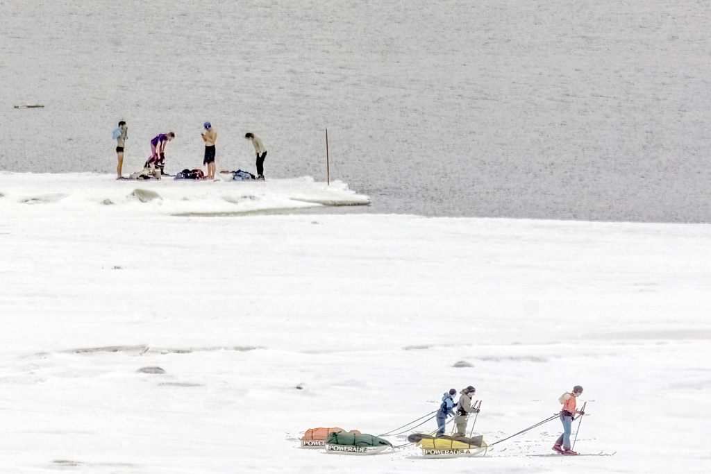 Different Pursuits Photograph of people in bathing suits in the snow and skiers