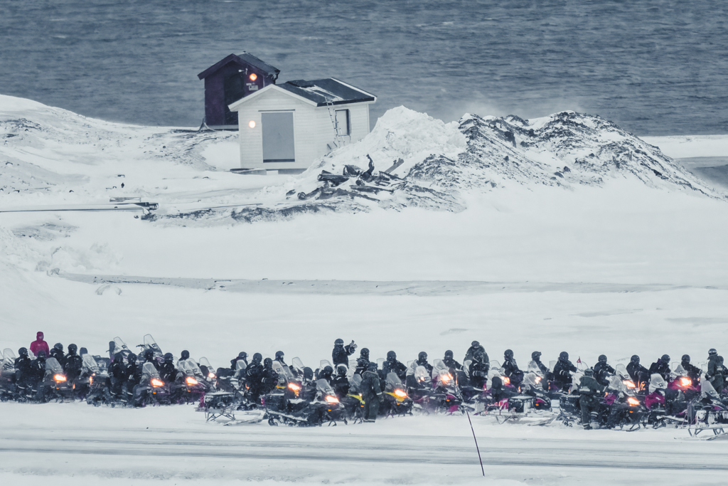 Winter Snowmobile Tourism Photograph of line of people with snowmobield waiting to go on a tour